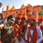 A woman dressed as Jhansi ki Rani, left, takes a selfie with members VHP women’s wing Durga Vahini in front of Ram Mandir replica