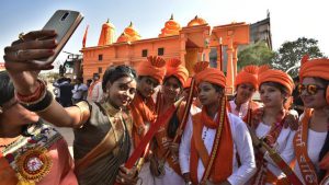 A woman dressed as Jhansi ki Rani, left, takes a selfie with members VHP women’s wing Durga Vahini in front of Ram Mandir replica