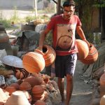 A worker collecting the finished earthen water coolers in Mansoorwal village on the outskirts of Kapurthala