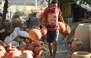 A worker collecting the finished earthen water coolers in Mansoorwal village on the outskirts of Kapurthala