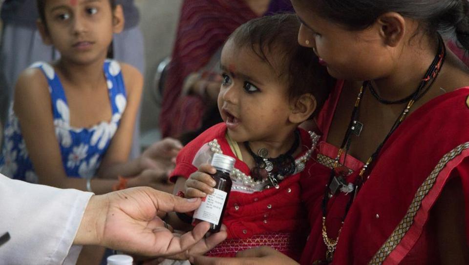 An infant accepts a bottle of medicine from a doctor at a Mohalla Clinic in Todapur village in Delhi. Infant mortality rate in India was forty per thousand live births, a very high rate, owed to very restricted access to neonatal care in rural areas
