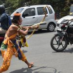 Artists dressed as characters of Ramayana performing amid traffic during a road show on the occasion 9th day of Navratri at a Hanuman Temple near Kempegowda Railway Station in Bengaluru