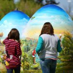 Children look at two-metre-high Easter eggs painted in the traditional naive art style in Koprivnica, Croatia, April 9