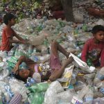 Children rest on plastic bottles after playing on Earth Day in Allahabad, India.