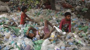 Children rest on plastic bottles after playing on Earth Day in Allahabad, India.