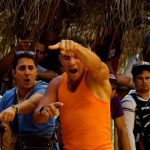 Cockfighting enthusiasts react during a fight