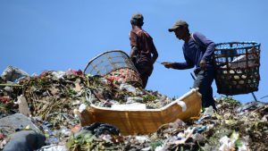 Indonesian scavengers carry items salvaged from a garbage dump in Denpasar. The theme for this year's Earth Day, which is marked on April 22, is Environmental and Climate Literacy.
