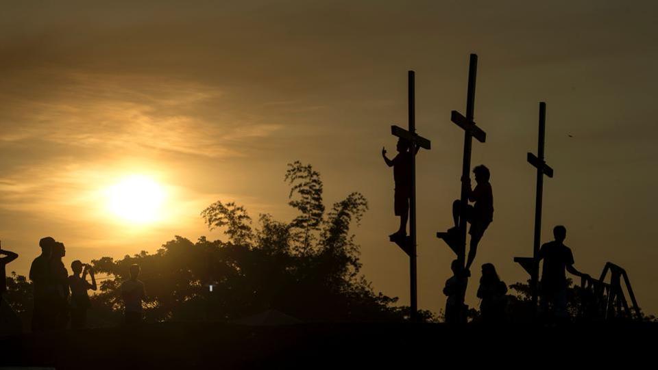 Local tourists pose with the crosses before a re-enactment of the crucifixion of Jesus Christ. Lent represents the time Jesus spent fasting in the desert, before starting his public ministry, where he endured temptation by Satan