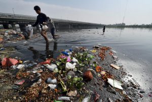 Ragpickers search for coins, gold and offerings in the polluted waters of the Yamuna River after the Navratri festival