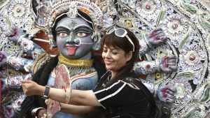 A visitor taking a picture with the idol of Goddess kali.