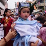 A young girl (C) dressed as a deity takes part in a parade. Young children in intricate outfits -- posing as deities, local sporting heroes and even politicians gave the impression of floating above the crowds as they were wheeled around on high pedestals.