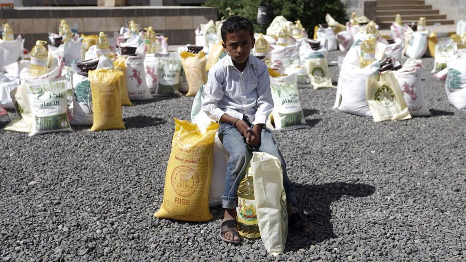 A Yemeni boy sits next to food aid distributed by a local charity during the Muslim holy fasting month of Ramadan, in the capital Sanaa.