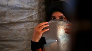 A displaced Syrian woman waits to receive food aid on June 9, 2017 at the al-Mabrouka camp in the village of Ras al-Ain on the Syria-Turkey border, where many Syrians who fled from territory held by the Islamic State (IS) group in Raqa are taking shelter.