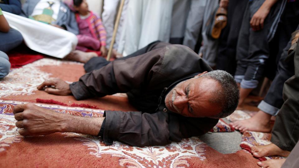 A man lies on the ground as he receives fatigue treatment during a day of fasting in Sanaa