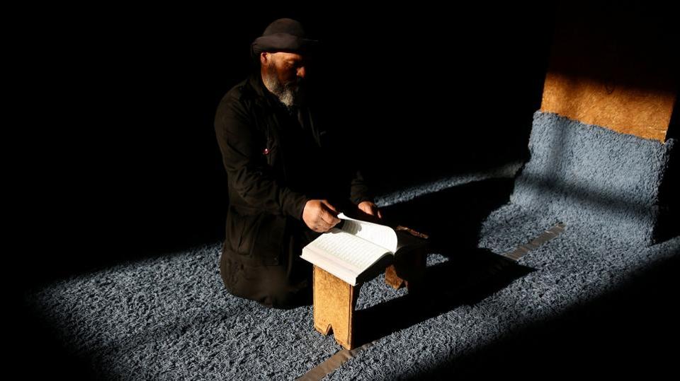 A man reads the Quran during Ramadan in the rebel held Damascus suburb of Ghouta.