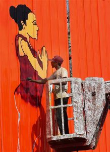 A street artist paints a wall with yoga postures ahead of International Yoga Day in New Delhi on June 20, 2017