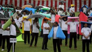 BSF Personnel use yoga mats to protect themselves from rainfall during a group session on International yoga day, in Jammu, Jammu and Kashmir