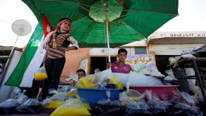 Members of the Syrian refugee troupe Abu Rustom, sell traditional juices at the Al-Zaatari refugee camp near the border with Syria.