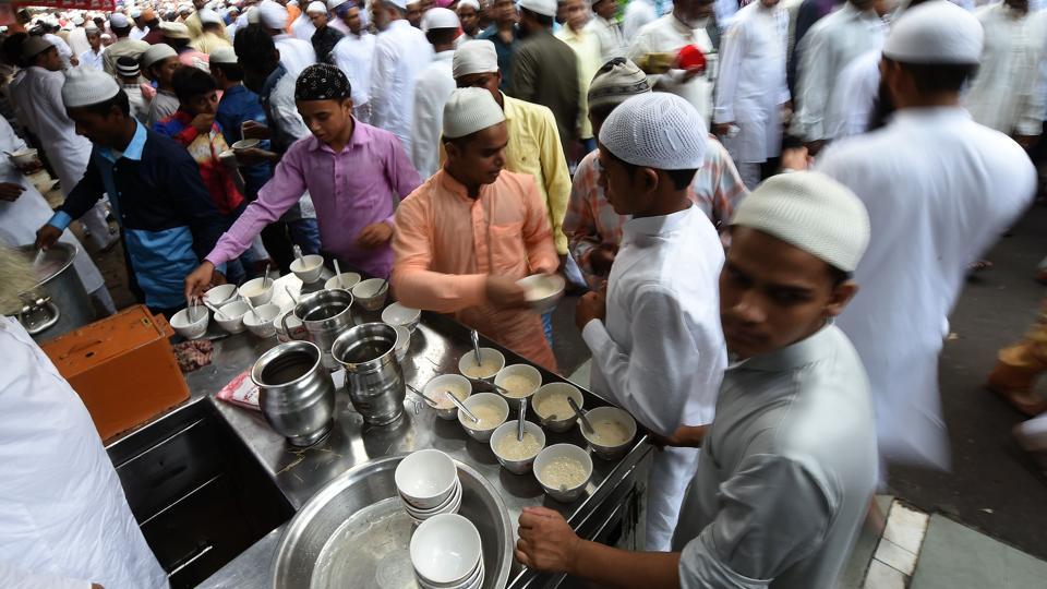 Muslims serve ‘seviyan’, a sweet vermicelli dish, after offering prayers during Eid al-Fitr at the Jama Masjid mosque