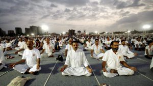 People practice asanas during a mass yoga session on the third day of Baba Ramdev Yoga camp in Ahmedabad, Gujarat on June 20, 2017.