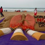 Sand artist Manas Sahoo creates a sand sculpture on eve of 'World No Tobacco Day', in Puri, on Tuesday.