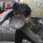 A man being splashed in the face with a wave of mud marks the start of the Mud Festival in Boryeong, South Korea.