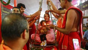 A woman and her child are weighed on a weighing scale to donate their equivalent weight in food items during Ganesh Chaturthi festival celebrations in Mumbai. Ganesh Chaturthi is believed to mark the birth anniversary of the deity and is celebrated on the fourth day (chaturthi) of the Hindu calendar month of Bhadrapada.