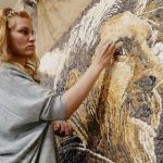 Anna Solnechnaya shows her creation of one of the pebble mosaics depicting Argentina's Lionel Messi in Kazan
