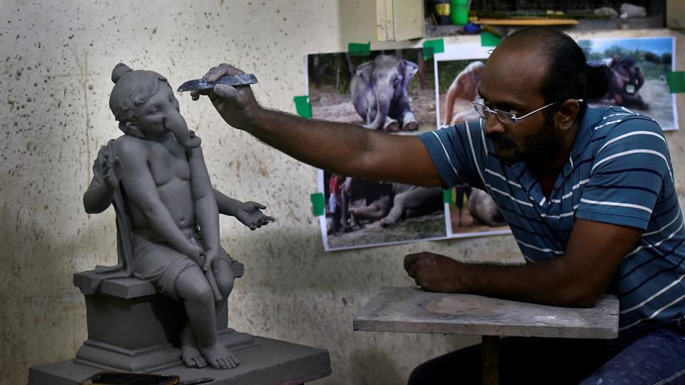 Artist Vishal Shinde works on a clay idol.