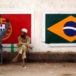 Football fans paint the flags of Portugal and Brazil on the wall of a low-income neighbourhood in Karachi, Pakistan