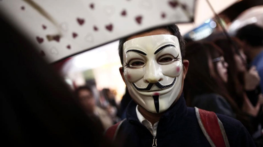 A man wearing an Anonymous mask takes part in a Halloween parade in Tokyo.