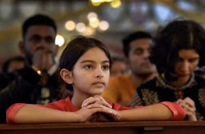 A girl attends a Mass at the Santhome Church on the occasion of Christmas festival in Chennai on December 25, 2017