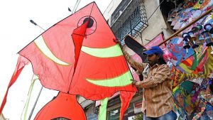 A shopkeeper shows off a huge fish-shaped kite at his shop in Bandra.