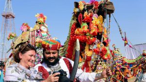 A tourist shows a picture to a camel owner during the inaugural ceremony of International Camel Festival in Bikaner.
