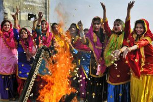 College students, wearing traditional Punjabi dresses, dance during the Lohri festival celebrations in Amritsar on January 12, 2018.