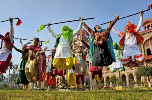 College students, wearing traditional Punjabi dresses, dance during the Lohri festival celebrations in Amritsar on January 12, 2018.