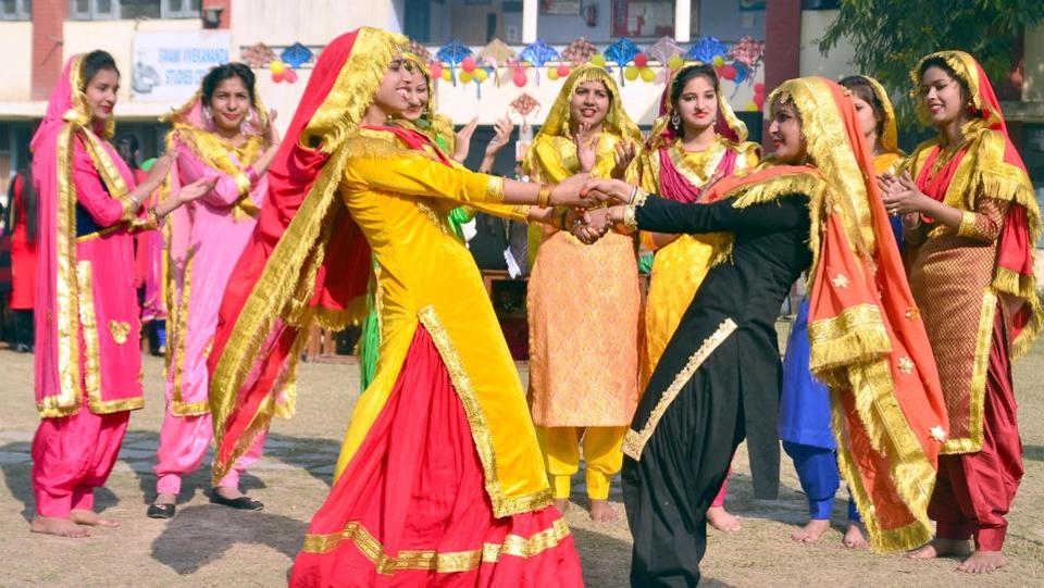 Students wearing traditional Punjabi dresses dance during Lohri in Amritsar.
