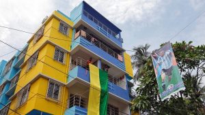 Fans hang a large flag from a residential building next to a banner featuring Argentina's Lionel Messi.