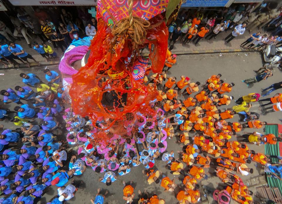 A Hindu devotee breaks a dahi-handi suspended in the air atop a human pyramid during celebrations for the Janmashtami festival, which marks the birth of Hindu God Lord Krishna, at Dadar in Mumbai, Maharashtra.