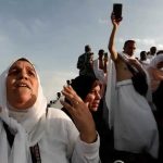 A Muslim pilgrim prays as she gather with others on Mount Mercy (Jabal ar-Rahmah) on the plains of Arafat during the annual Hajj pilgrimage on August 20, 2018. Muslims believe prayer on Mount Arafat, about 20 kilometers east of the holy city of Mecca, is their best chance to erase past sins and start anew.