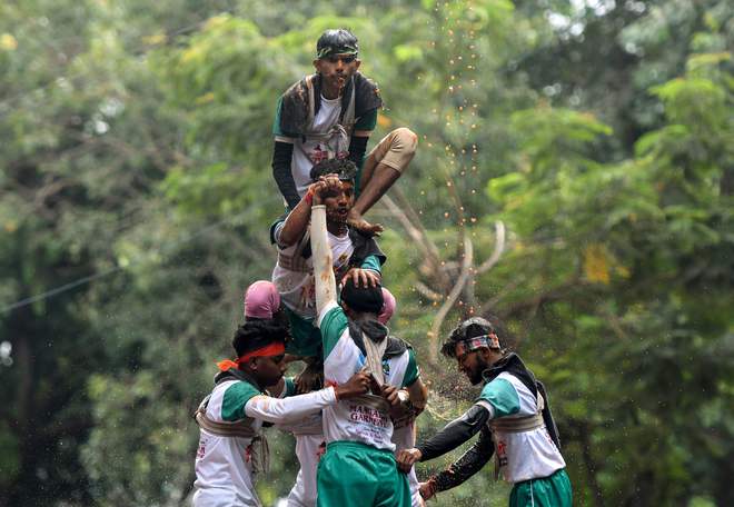 Hindu devotees form a human pyramid to break a Dahi Handi suspended in the air during celebrations for the Janmashtami festival in Mumbai