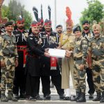 Pakistani Wing Commander Bilal (4L) presents sweets to Indian Border Security Force (BSF) Commandant Sudeep (2R) during a ceremony to celebrate Pakistan's Independence Day at the India-Pakistan Wagah border post at Attari