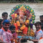 Devotees spray water on a statue of Lord Ganesha during immersion ceremony at Ghaggar River in Panchkula, Haryana