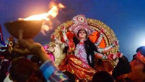 Devotees carry an idol of Goddess Durga for immersion in a pond near Ganges River