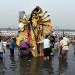 Devotees immerse an idol of goddess Durga in Yamuna river at Kalindi Kunj, New Delhi