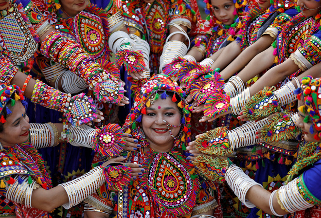 Participants dressed in traditional attire pose for pictures during rehearsals for Garba, a folk dance, in preparations for the upcoming Navratri in Ahmedabad on September 25, 2019.