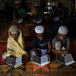 Saleema Khanam (L), studies inside a makeshift madrassa with other students in Kutupalong camp, near Cox's Bazar. She takes her position in the front, flanked by two brothers, and opens the book. “I come here to learn the Quran. My mother wants me and my brothers to learn, to become better people,” the young student told.