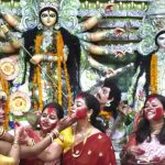 Women smear each other with vermillion during the Bengali tradition of Sindur Khela on Dussehra at Aram Bagh Durga Puja pandal in New Delhi