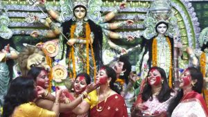 Women smear each other with vermillion during the Bengali tradition of Sindur Khela on Dussehra at Aram Bagh Durga Puja pandal in New Delhi