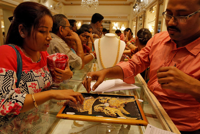 A salesman shows gold necklaces to a customer at a jewellery showroom during Dhanteras, a Hindu festival associated with Lakshmi, the goddess of wealth, in Kolkata